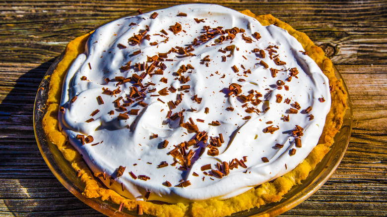 overhead shot of whole chocolate cream pie topped with whipped cream and chocolate shavings