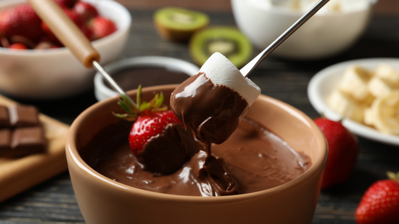 strawberry and marshmallow being dipped in chocolate fondue