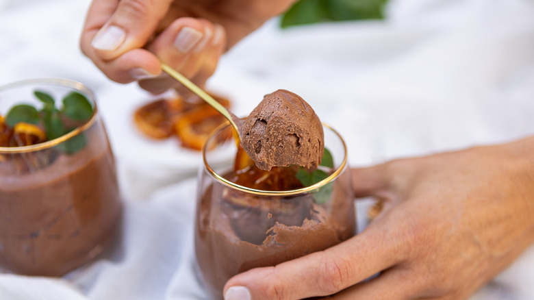 Hand holding spoonful of airy chocolate mousse