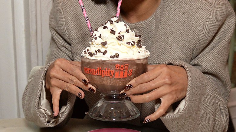 Hands holding frozen hot chocolate dessert from Serendipity 3