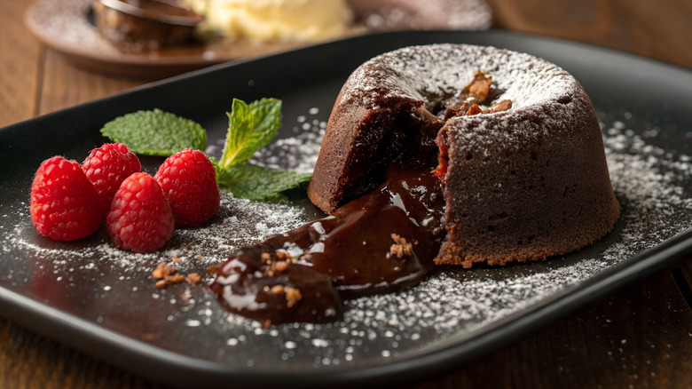 molten chocolate cake cut into with gooey center flowing out