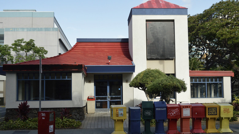 A closed KFC location in Honolulu, HI, its sign covered with black paint.