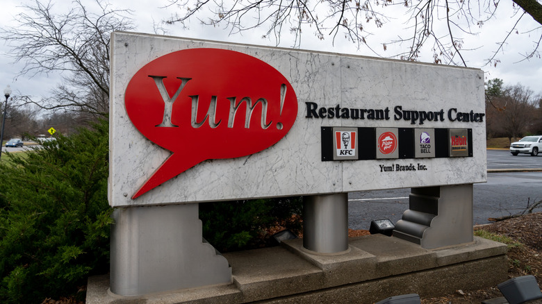 Sign outside Yum! Brands' Restaurant Support Center, displaying the logos of Yum! subsidiaries KFC, Pizza Hut, Taco Bell, Habit Burger.