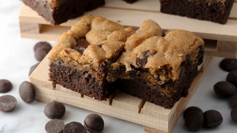 Two chocolate chip brookie squares on wooden board