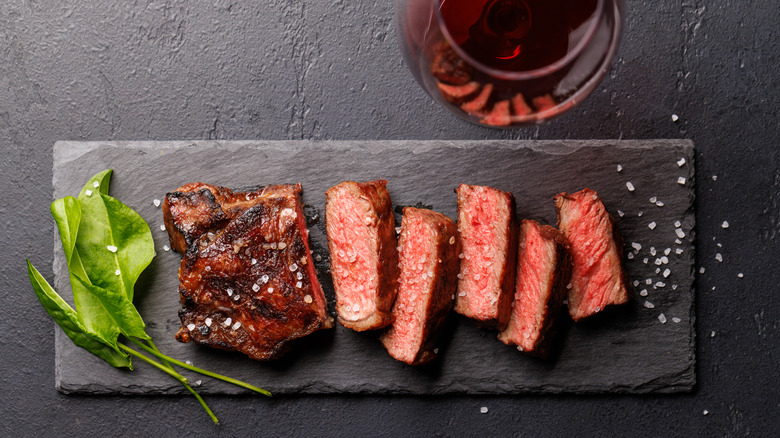 Sliced steak on a black slate board