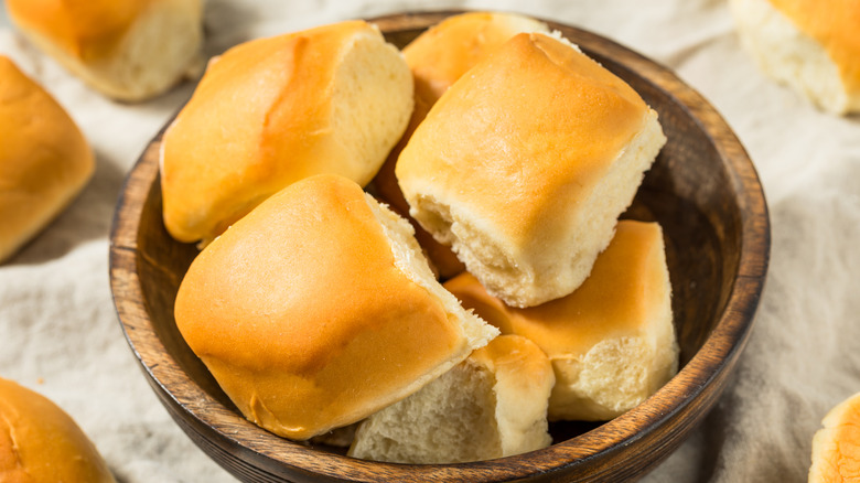 Dinner rolls in brown bowl on table