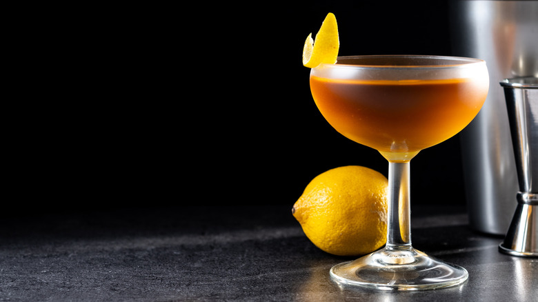 Paper plane cocktail next to a lemon