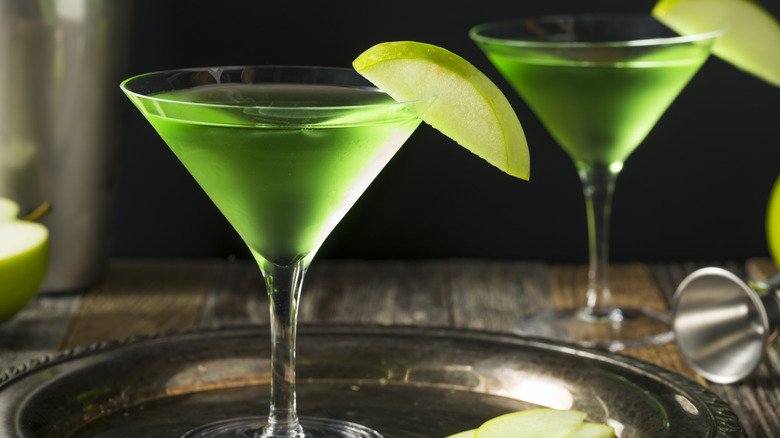 Bright green appletini cocktails garnished with apple slices