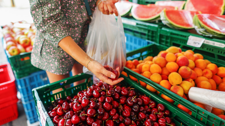 Person selecting cherries in market