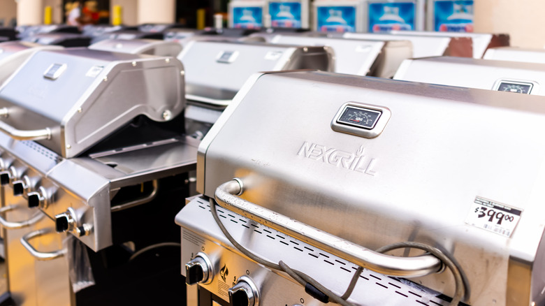 large display of shiny new gas grills outside a big-box retail store