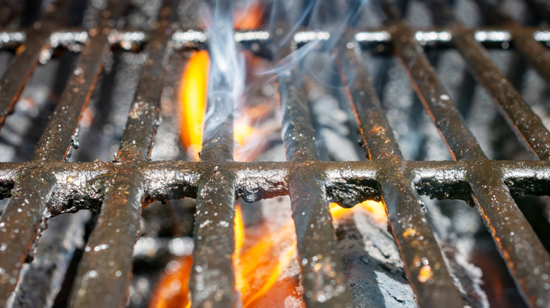 closeup image of dirty grates on a gas grill, being heated prior to cleaning