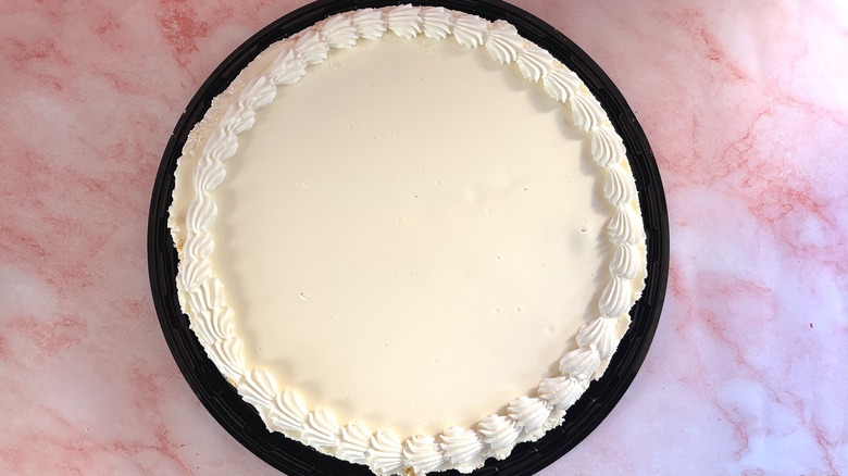Overhead shot of Costco cheesecake on tray on pink surface
