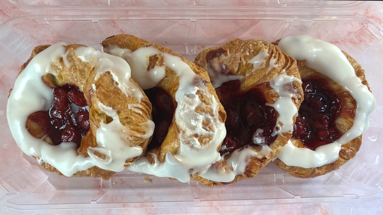 Overhead shot of box of Costco cherry danishes on pink surface