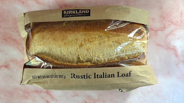 Top-down shot of Costco rustic Italian loaf in bag on pink table