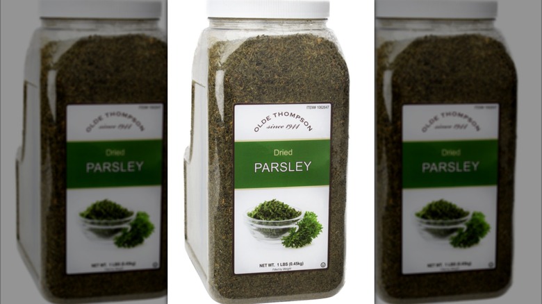 Big plastic container of dried parsley