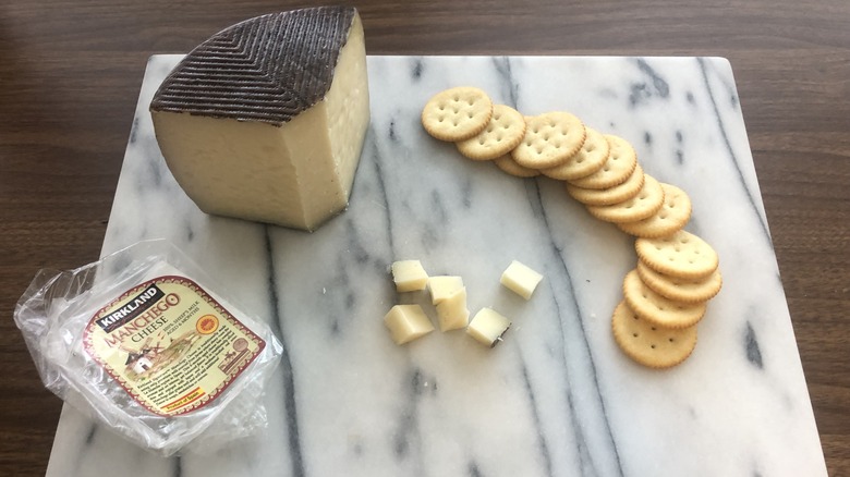 Kirkland Signature Manchego cheese on platter with crackers.