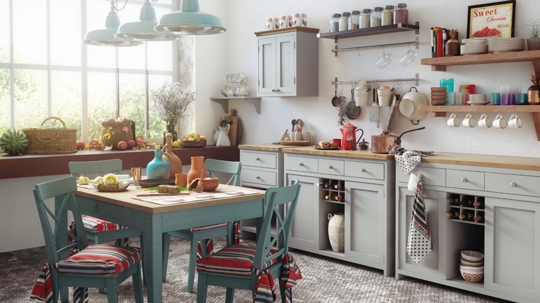 Retro-styled kitchen with gray cabinets, wooden counters, and soft teal table and chairs.
