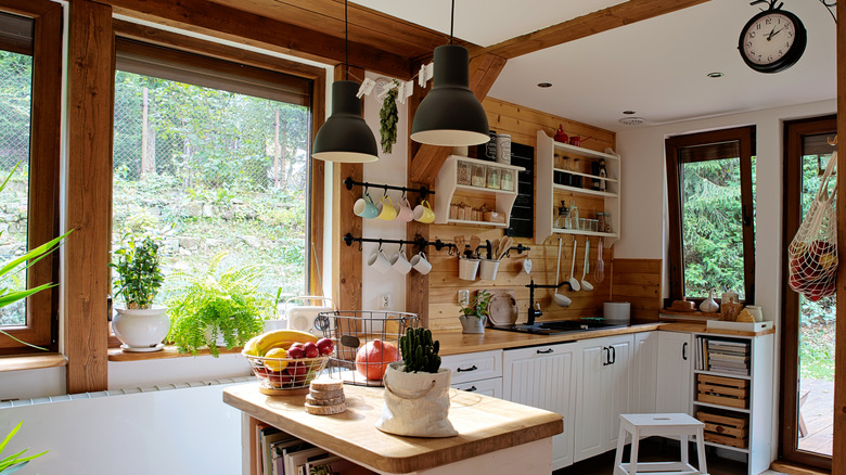 Cozy cottage style kitchen with lots of wood and pot plants and herbs drying