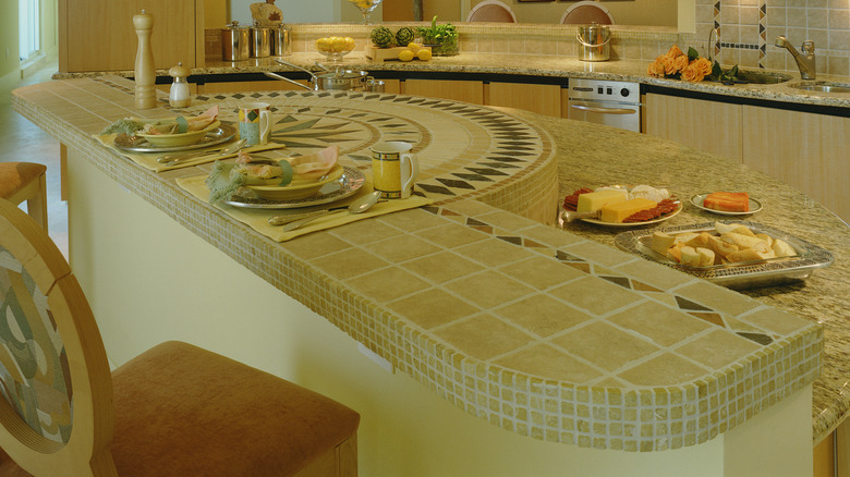 A kitchen island with a tiled portion of the countertop