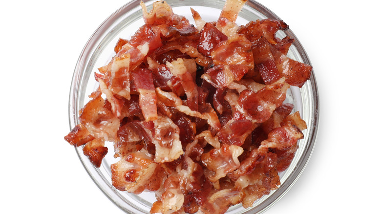 Fried bacon in a glass bowl isolated on a white background