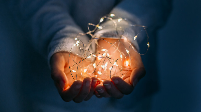 A string of fairy lights held in a pair of hands