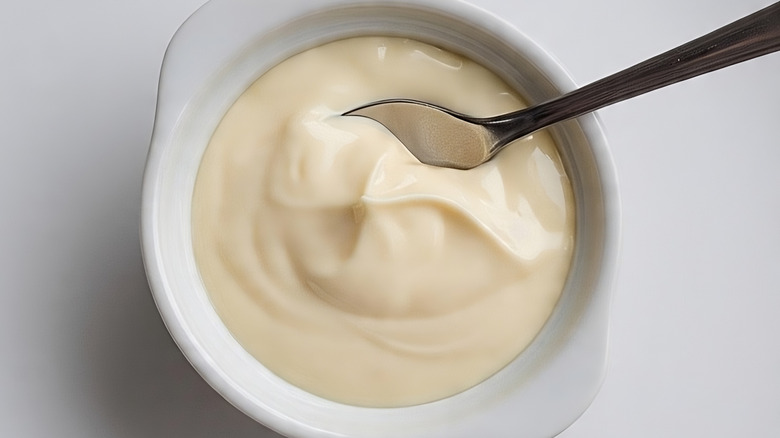 Mayonnaise in a small white bowl with a spoon