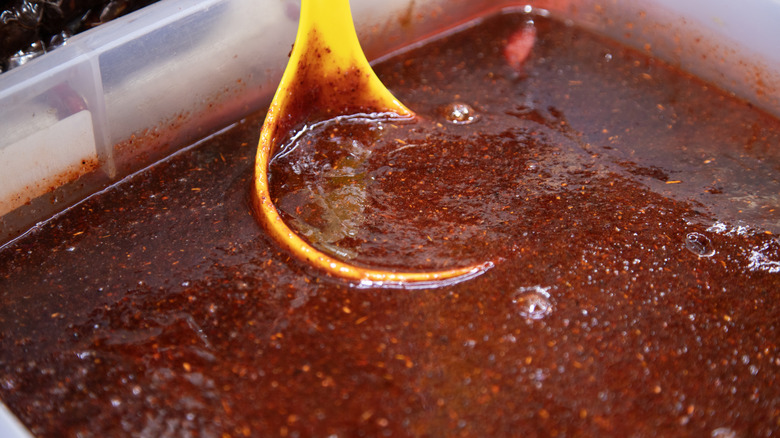 Chamoy with ladle in large plastic container