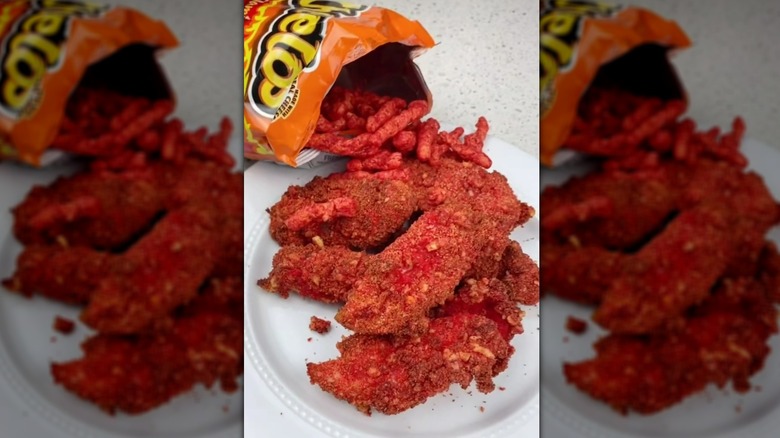 Cheeto-crusted chicken pieces on plate with bag of Cheetos spilling over
