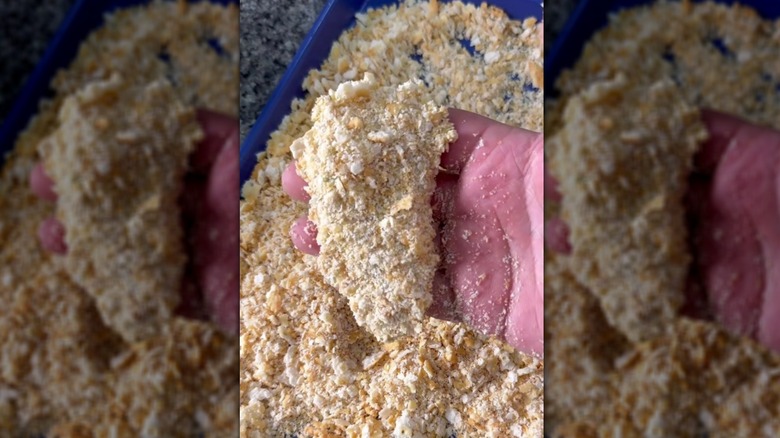 Coating chicken tender in crushed Ritz crackers
