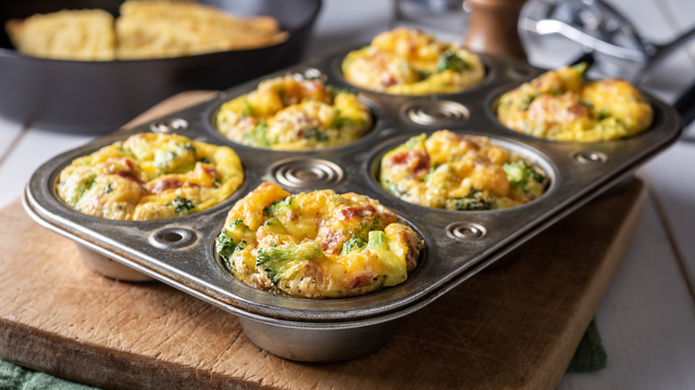 Breakfast egg muffins with broccoli, cheese, and bacon in muffin tin