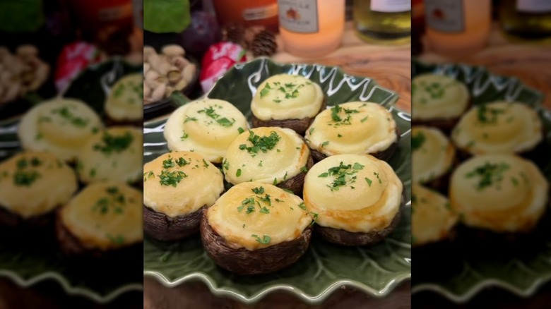 Babybel-stuffed mushrooms on plate, topped with fresh chopped parsley