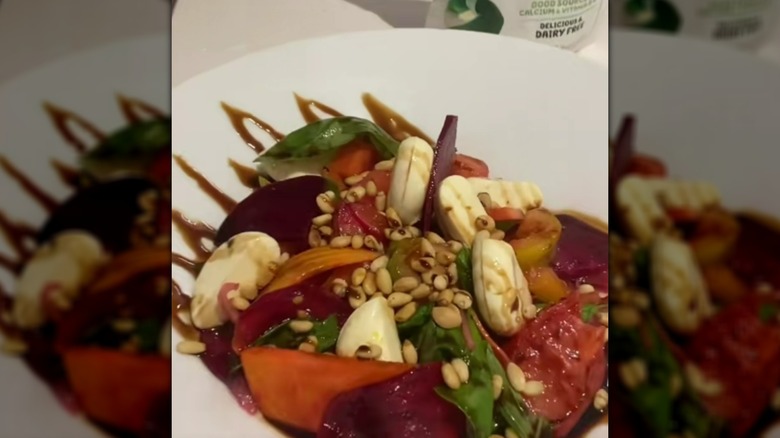 Tomato and basil salad with Babybel cheese, pine nuts, and balsamic glaze