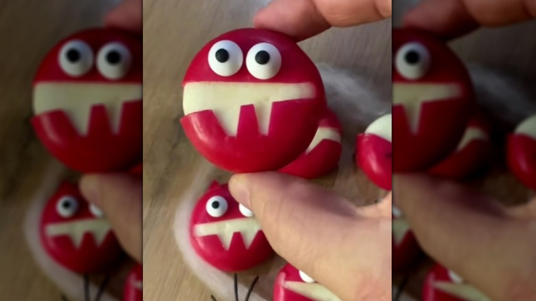 Hand holding Babybel "monster" with edible eyes