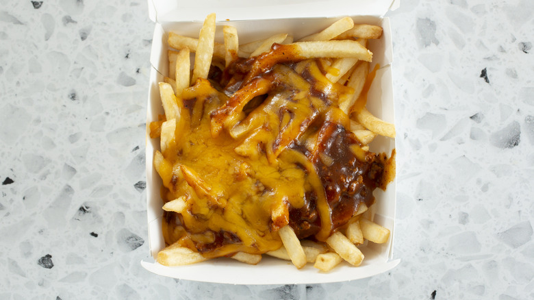 a container of chili cheese fries on a counter