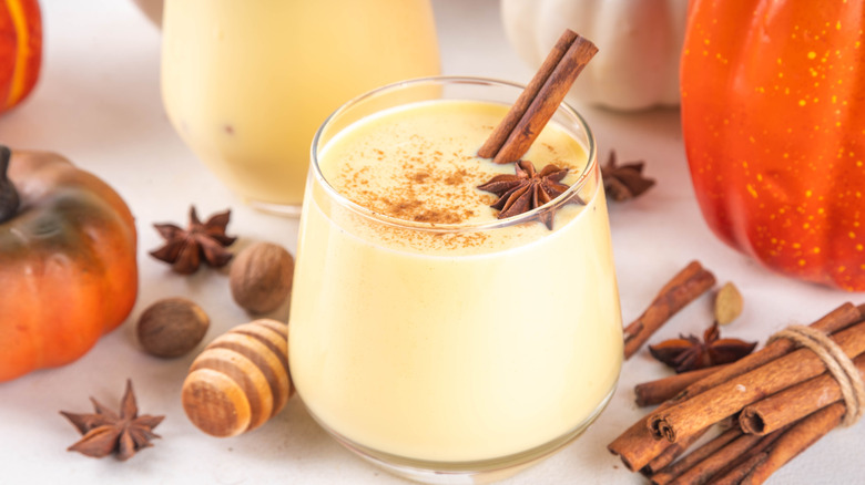 Spiced eggnog surrounded by pumpkin decor