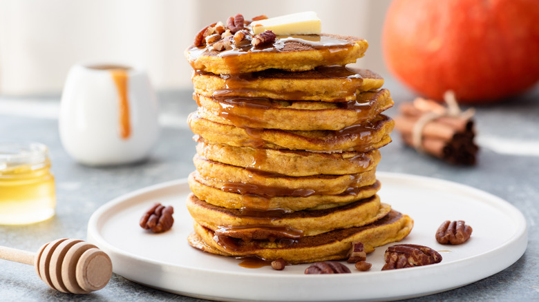 A plate with a high stack of pumpkin pancakes