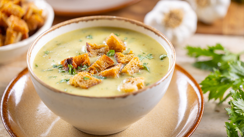 Bowl of creamy soup garnished with croutons and parsley