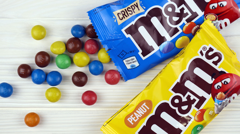 Crispy and Peanut M&Ms spilling from packets