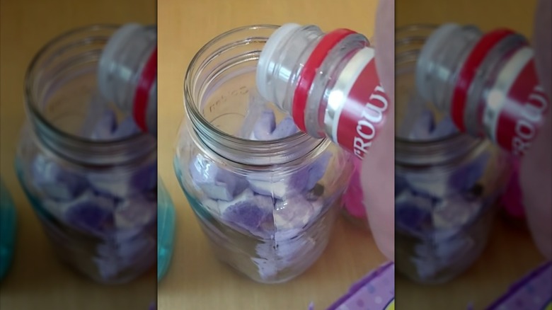 Pouring vodka over purple Easter Peeps in glass jar