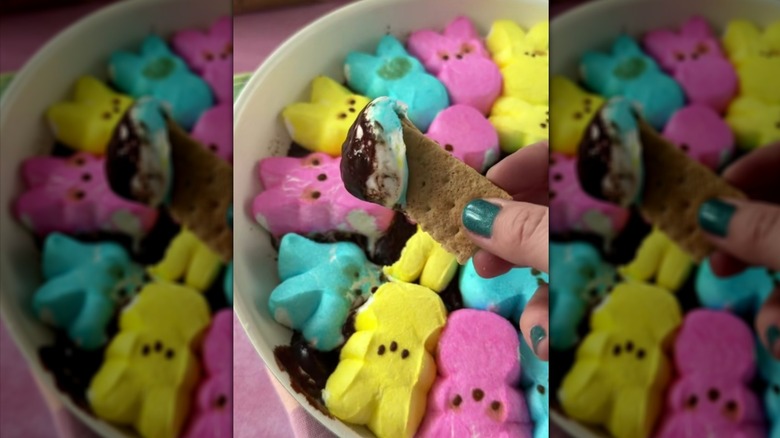 Dipping graham cracker into Easter Peeps s'mores dip