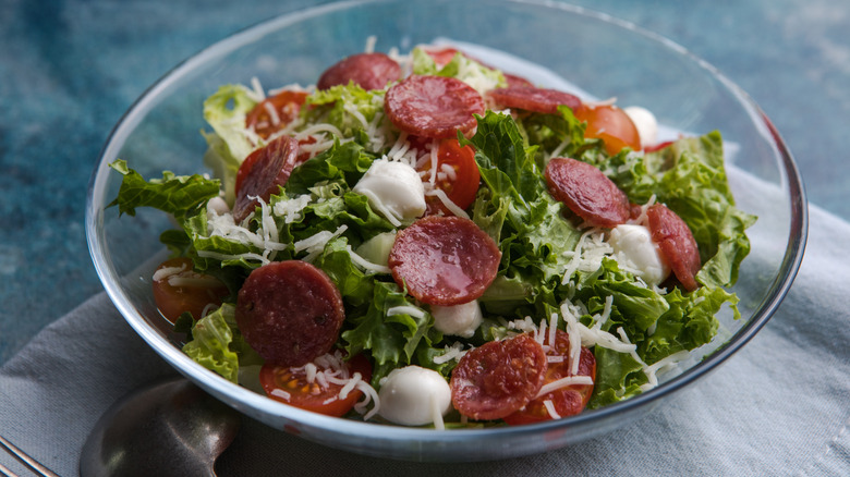 Bowl of pepperoni salad with lettuce and mozzarella