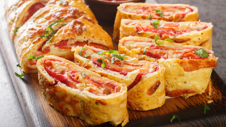 Sliced stromboli served on wooden board