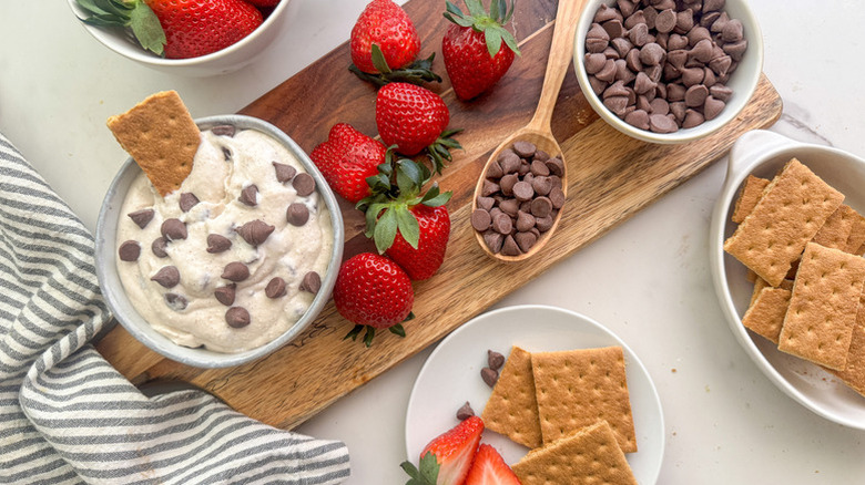 Bowl of cannoli-style dip with chocolate chips, graham crackers, and fresh strawberries