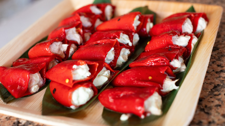 Ricotta-stuffed red peppers lined and stacked on serving platter