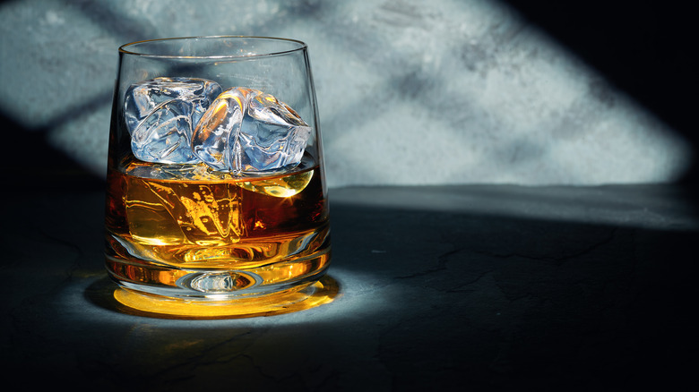 glass of bourbon on grey background