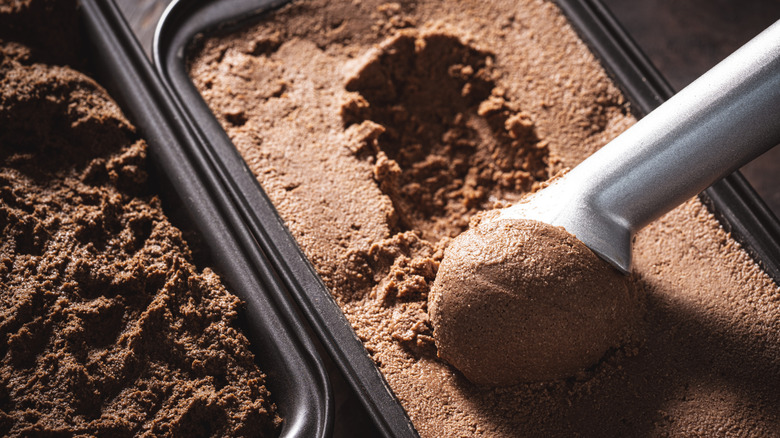 Silver ice cream scoop spooning up chocolate ice cream