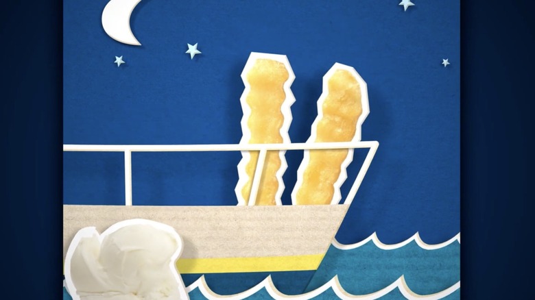 Two French fries on the deck of a ship with a crescent moon above them