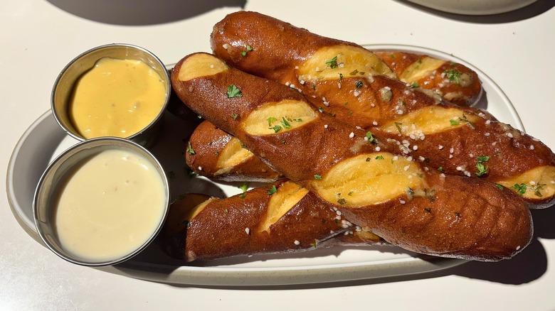 Dave & Buster's Soft Pretzel Sticks with queso and honey mustard on white plate on white table