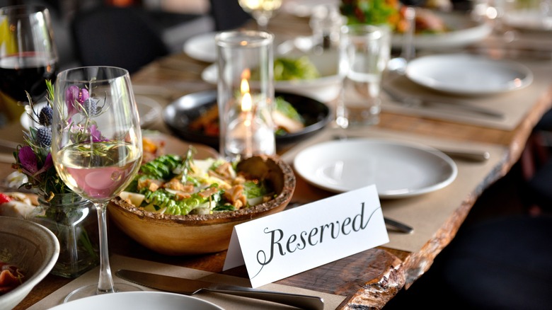 An elegant table setting with a reserved sign and a side dish of salad