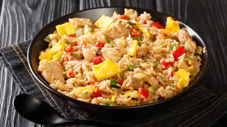 Arroz chaufa chicken and veg fried rice in black bowl